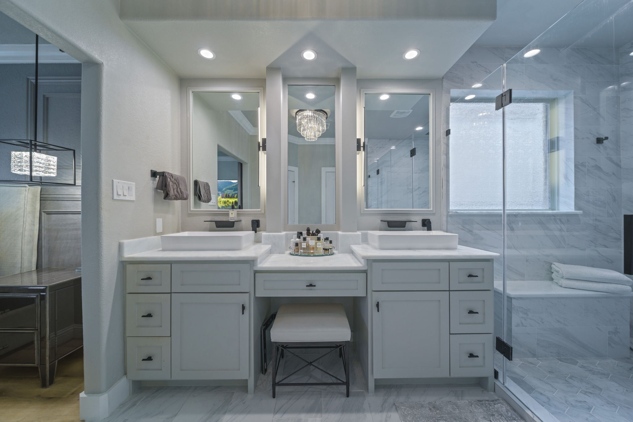 15 Inland Prairie Drive Tomball, TX 77375 - Photo 37 of 46 This a modern bathroom features dual sinks, elegant cabinetry, and a large glass-enclosed shower. The space is well-lit with recessed lighting and a stylish central chandelier, offering a luxurious and functional design.
