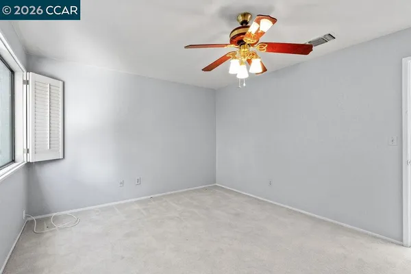 an empty room with a window and chandelier