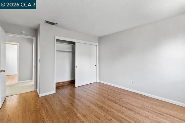 a view of an empty room with wooden floor