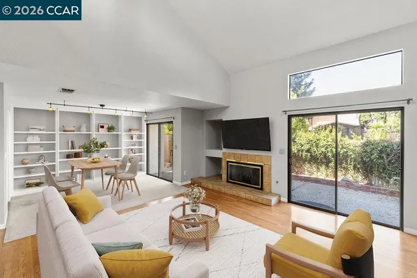 a living room with furniture fireplace and a large window