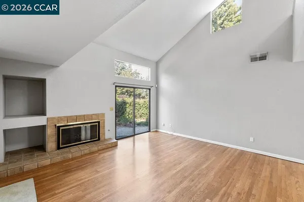 a view of an empty room with a fireplace and a window