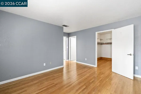 a view of an empty room with wooden floor