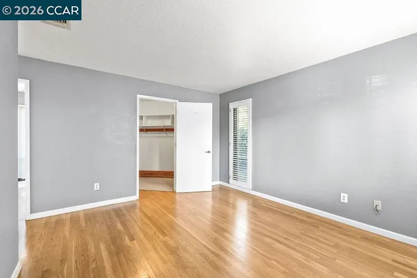 a view of an empty room with wooden floor
