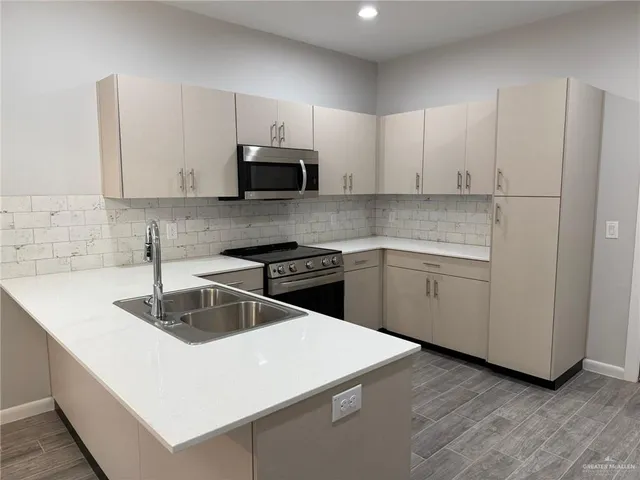 a large kitchen with stainless steel appliances granite countertop a stove and a sink