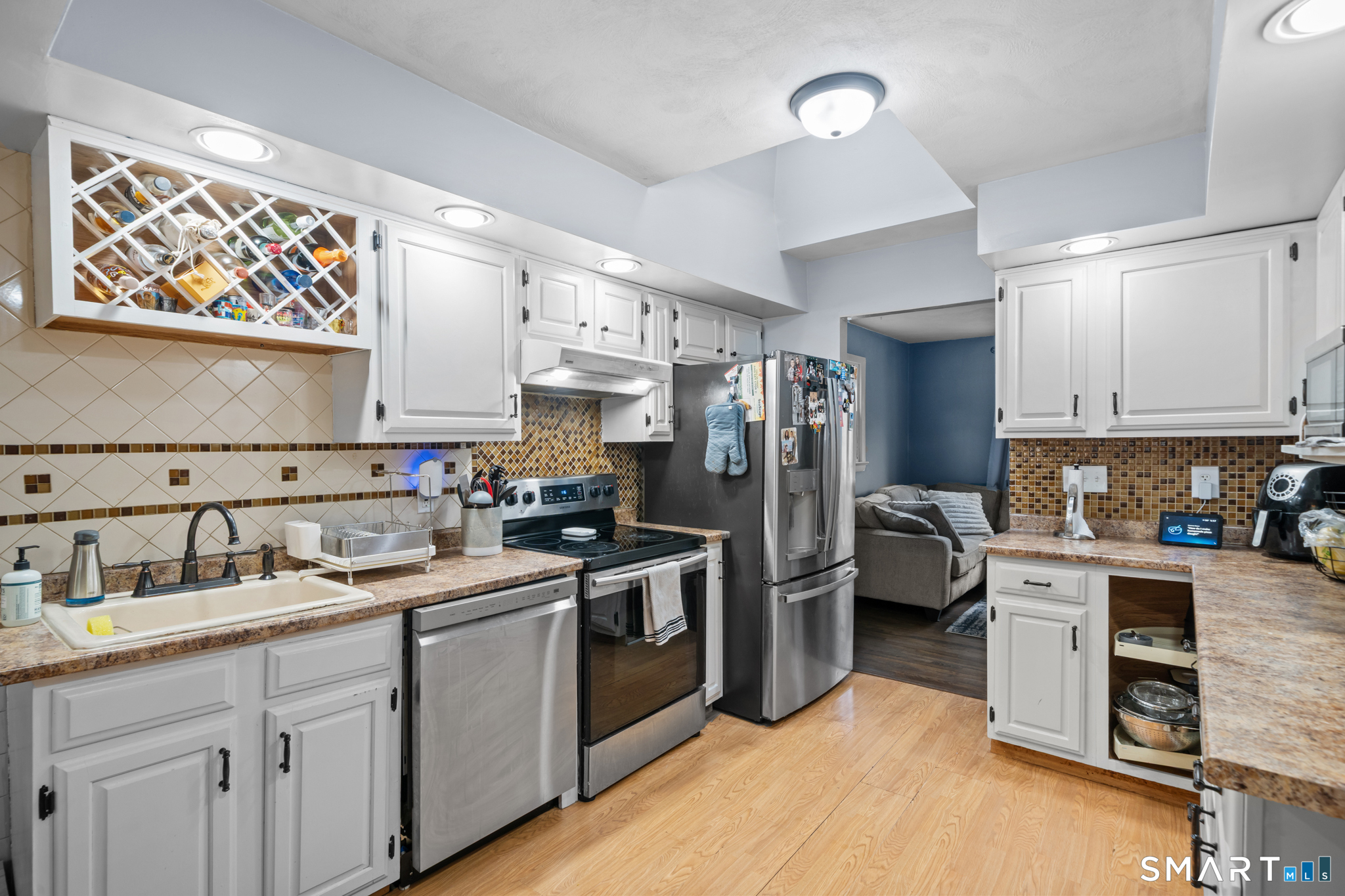 12 Lake Street Ledyard, CT 06339 - Photo 6 of 19 a kitchen with a sink dishwasher a stove and a refrigerator with wooden floor