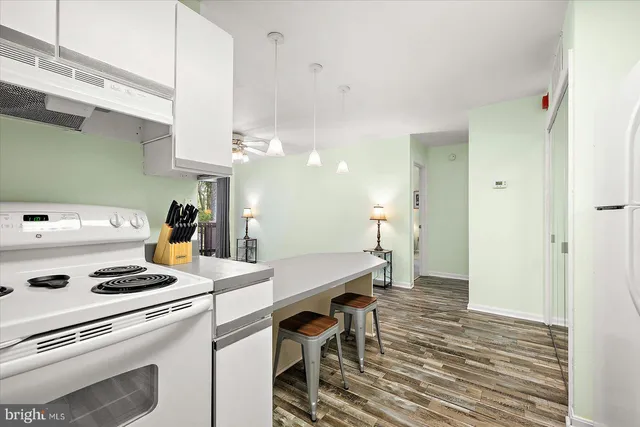 a kitchen that has a stove a table and chairs in it