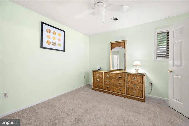 a room with painting on the wall and a dresser