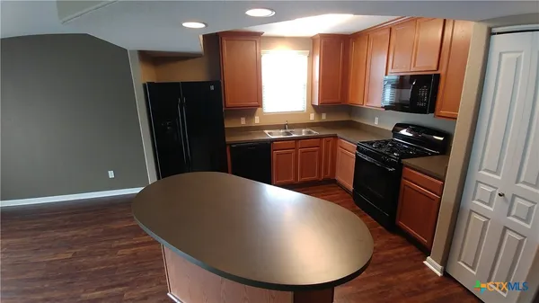 a kitchen with stainless steel appliances a refrigerator stove and microwave