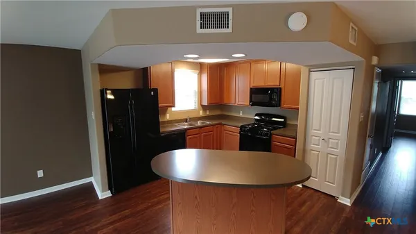 a kitchen with stainless steel appliances granite countertop a sink a stove and a refrigerator
