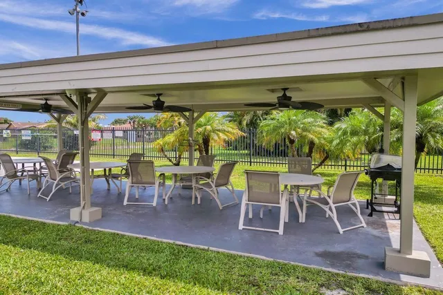 a view of a patio with table and chairs potted plants with wooden floor and fence
