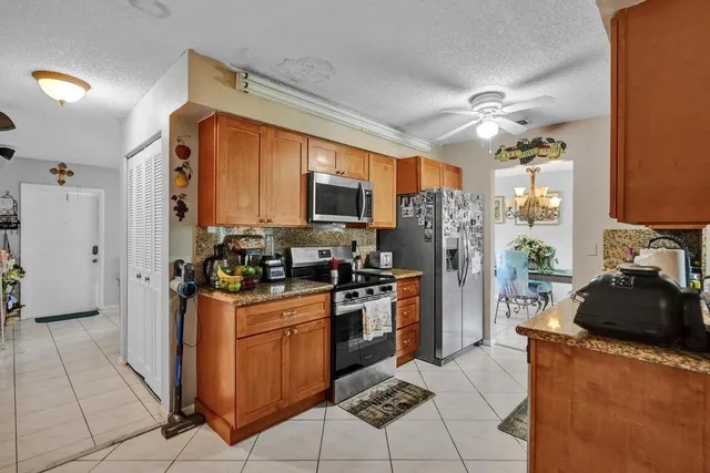 a kitchen with stainless steel appliances granite countertop a refrigerator stove top oven and sink