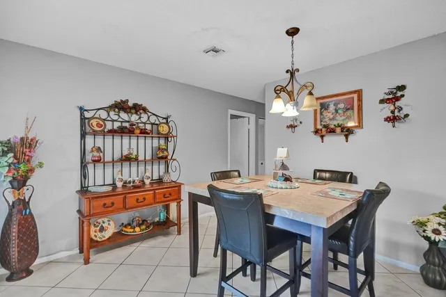 a dining room with furniture a chandelier and window