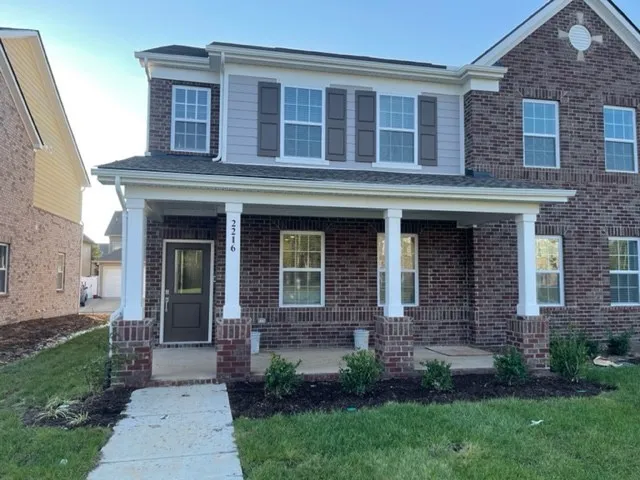 front view of a brick house with a yard