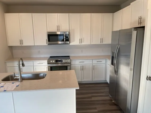 a kitchen with stainless steel appliances granite countertop a refrigerator sink and stove