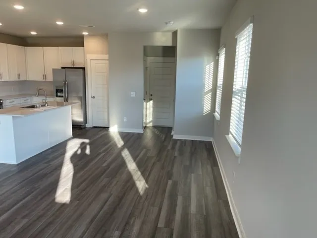a view of a kitchen with wooden floor and a window