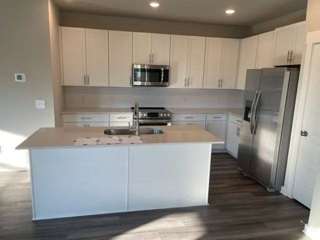 a kitchen with stainless steel appliances a refrigerator a stove a microwave and cabinets