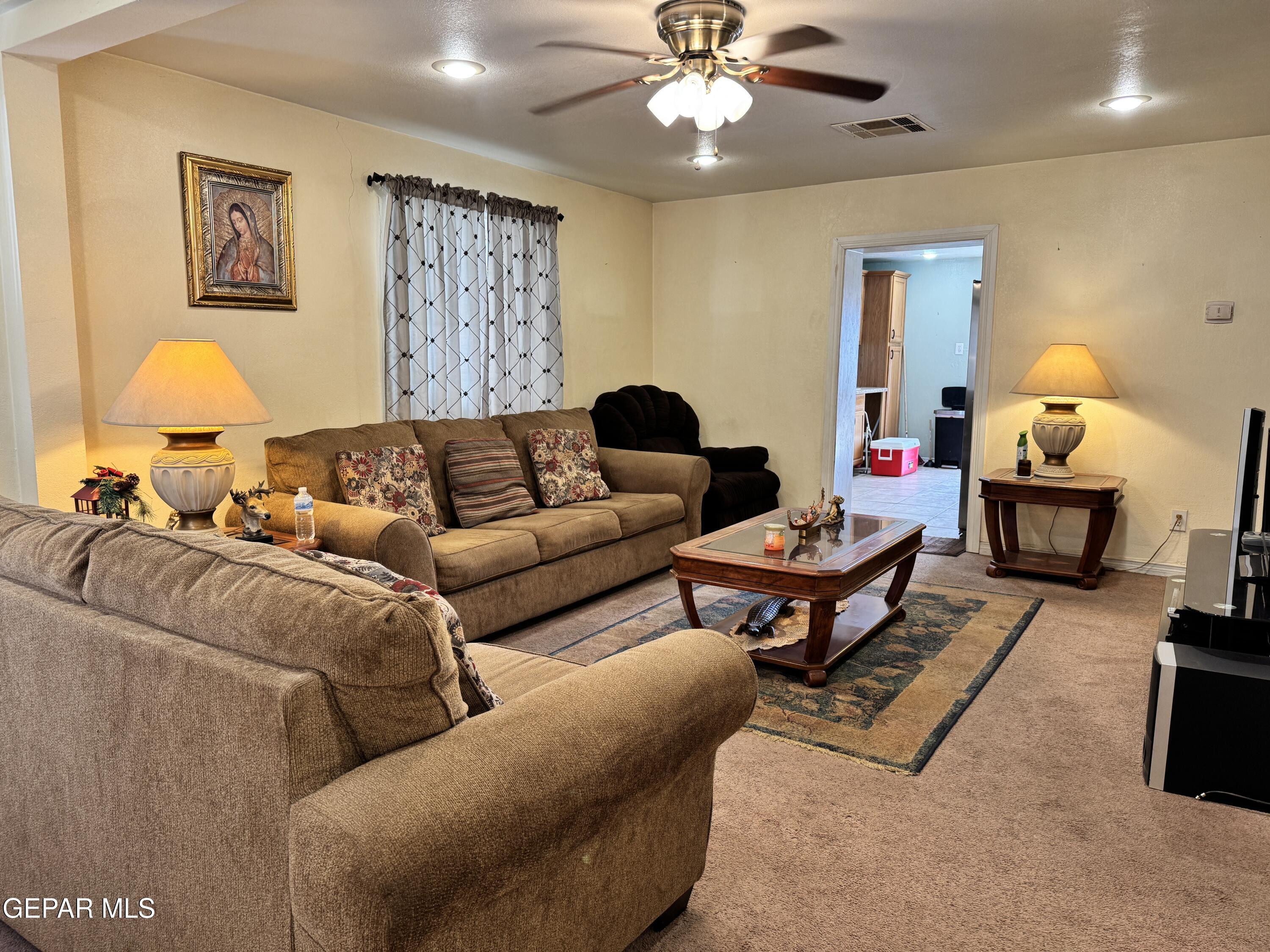 316 St Anthony Street Anthony, NM 88021 - Photo 6 of 29 a living room with furniture a lamp and a chandelier