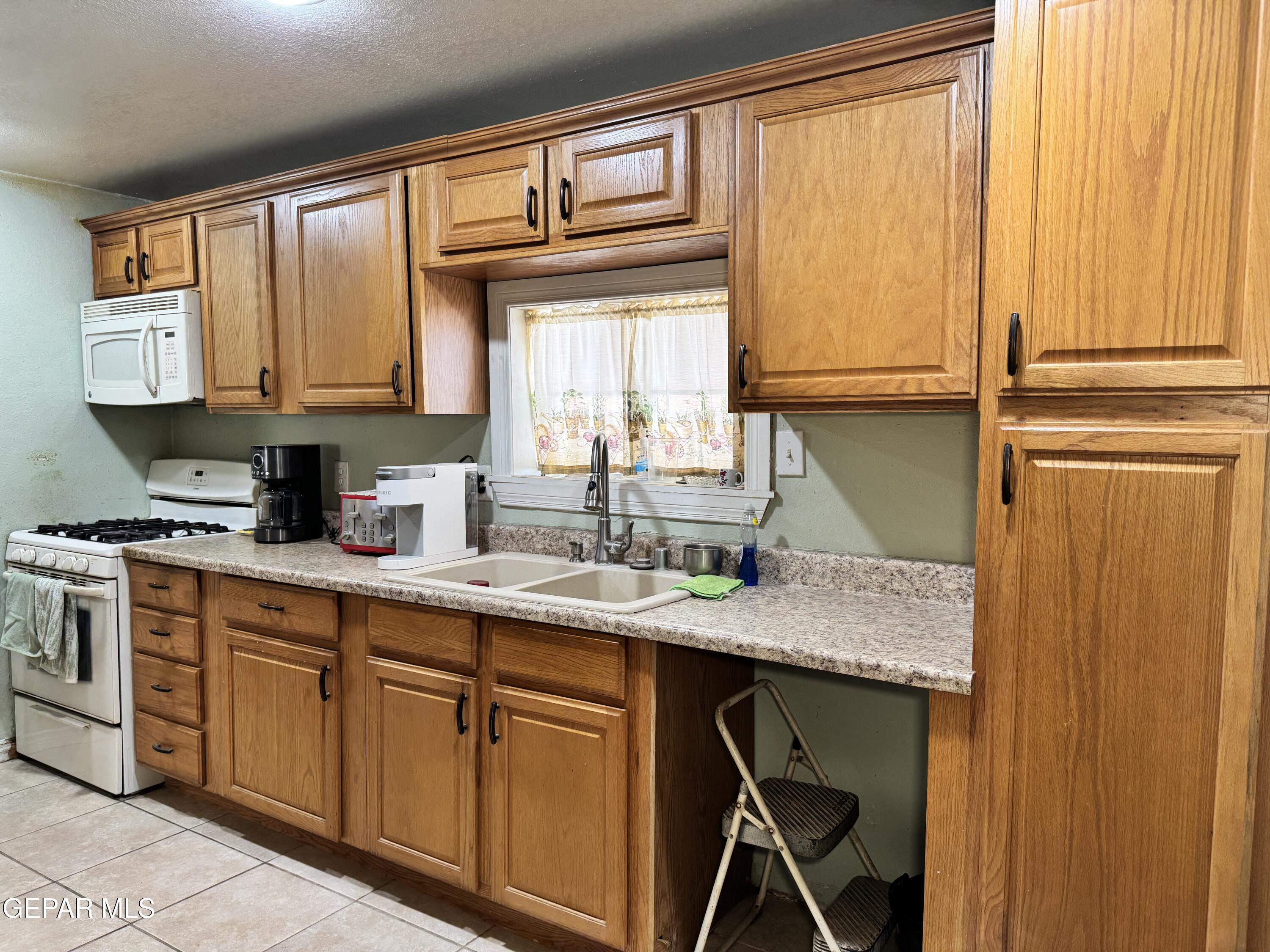 316 St Anthony Street Anthony, NM 88021 - Photo 9 of 29 a kitchen with stainless steel appliances granite countertop a sink and a window