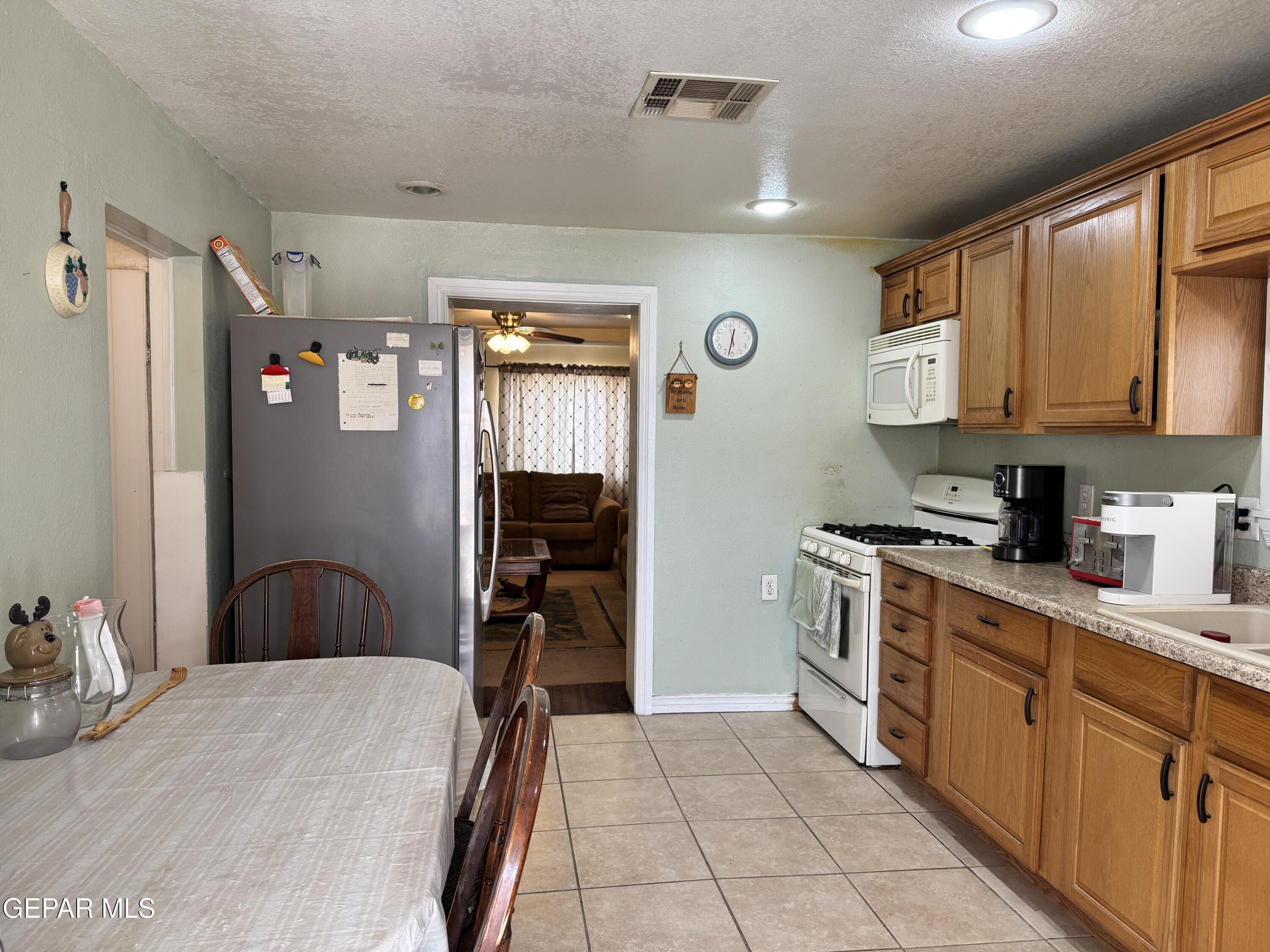316 St Anthony Street Anthony, NM 88021 - Photo 10 of 29 a kitchen with stainless steel appliances granite countertop a refrigerator and microwave