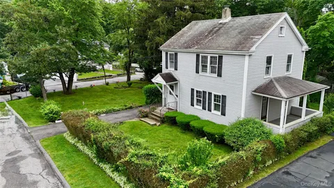 a aerial view of a house next to a big yard and large trees