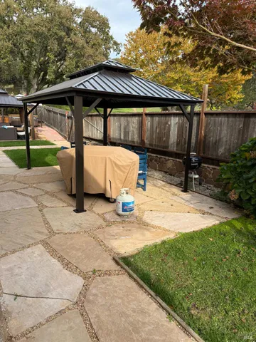a view of backyard with a patio and wooden fence