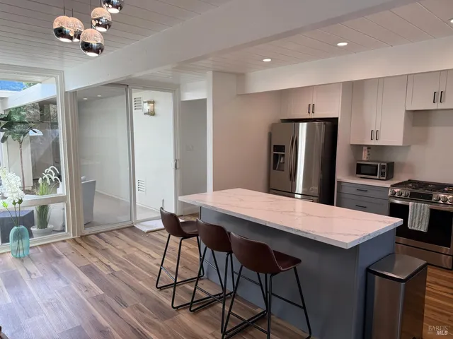 a kitchen with a table chairs refrigerator and cabinets