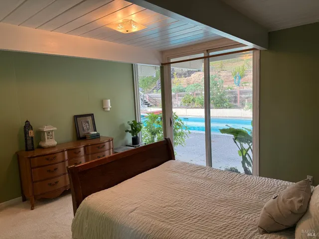 a bedroom with a bed and a large window