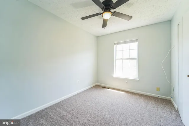 an empty room and chandelier fan