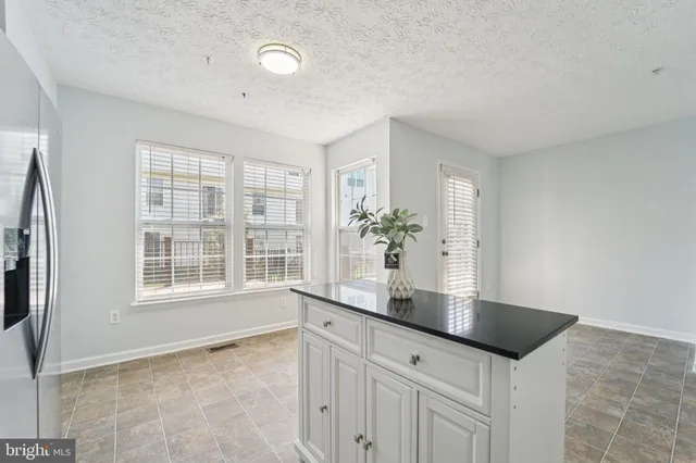 a kitchen with granite countertop a sink and a white cabinets