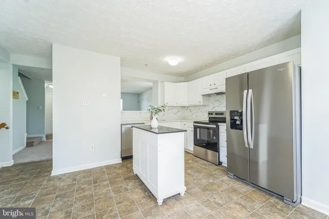 a kitchen with a refrigerator sink and stove