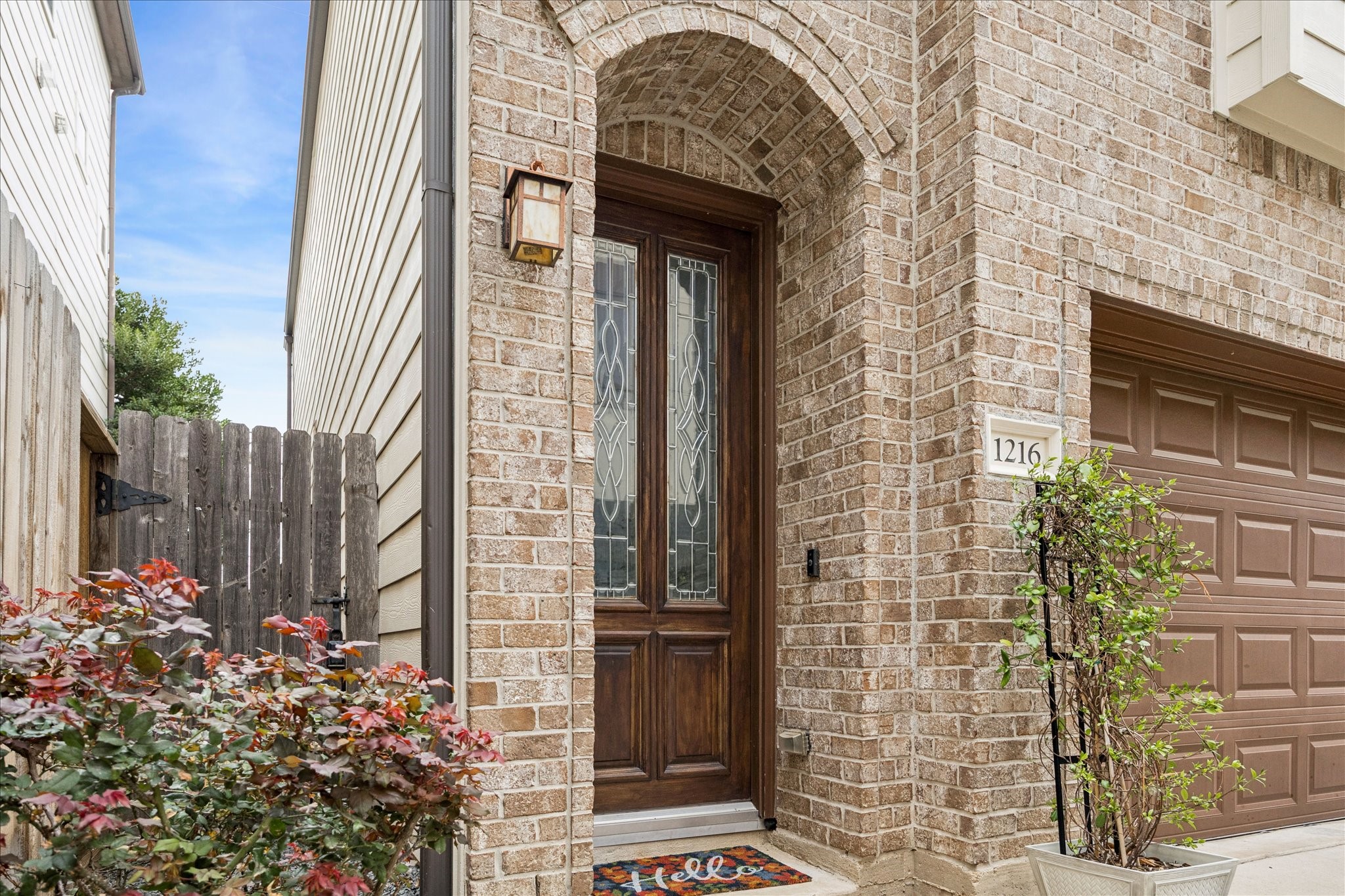 1216 Sampson Street Houston, TX 77003 - Photo 8 of 36 The arched brick entry frames a solid wood front door with decorative glass inserts, creating a welcoming first impression.