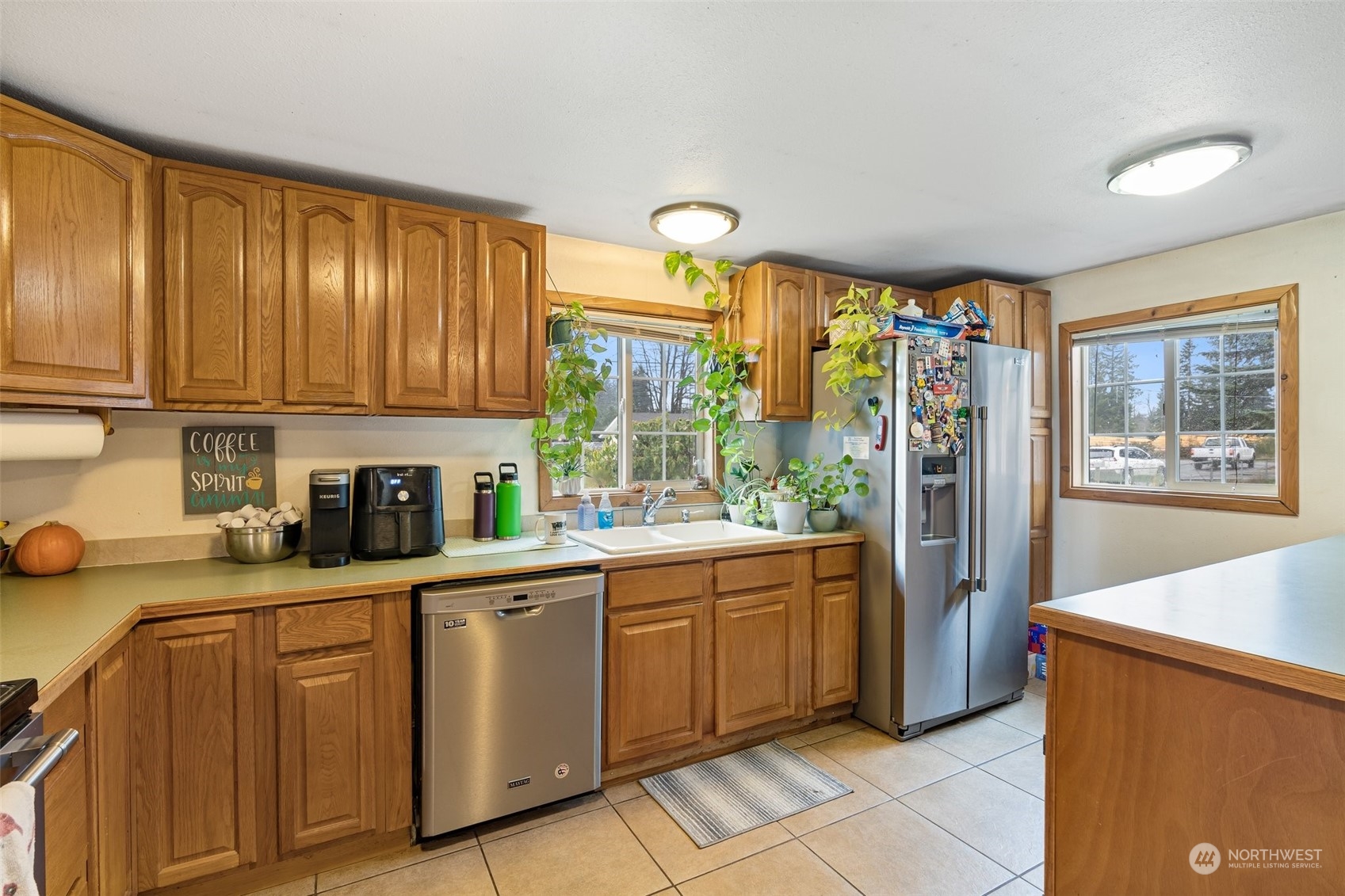 18116 Corvallis Street Southwest Rochester, WA 98579 - Photo 13 of 26 a kitchen with stainless steel appliances granite countertop a refrigerator a sink dishwasher and wooden cabinets with wooden floor