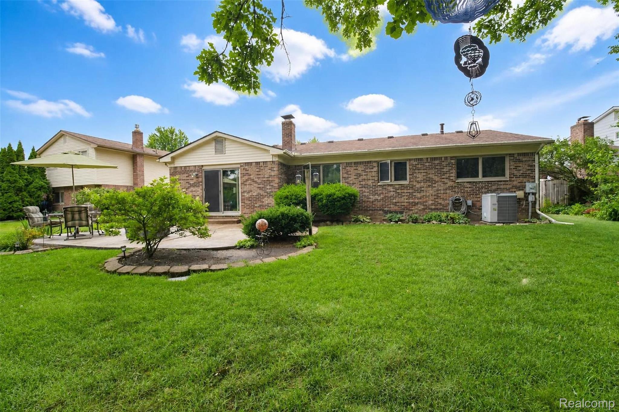 41768 Hanford Road Canton, MI 48187 - Photo 2 of 28 Expansive lawn with a paver patio and mature landscaping