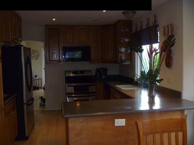 1200 Kokomo Road Haiku, HI 96708 - Photo 12 of 24 a kitchen with stainless steel appliances a refrigerator a stove a microwave a sink and cabinets
