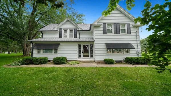 a front view of a house with a yard and green space