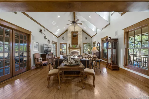 a living room with lots of furniture hardwood floor and a large window