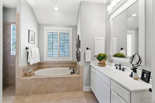 a bathroom with a bathtub sink and mirror