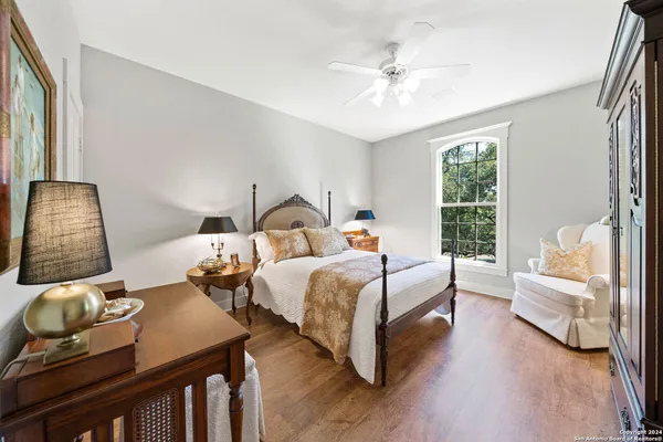 a bedroom with two beds and a large mirror next to a window