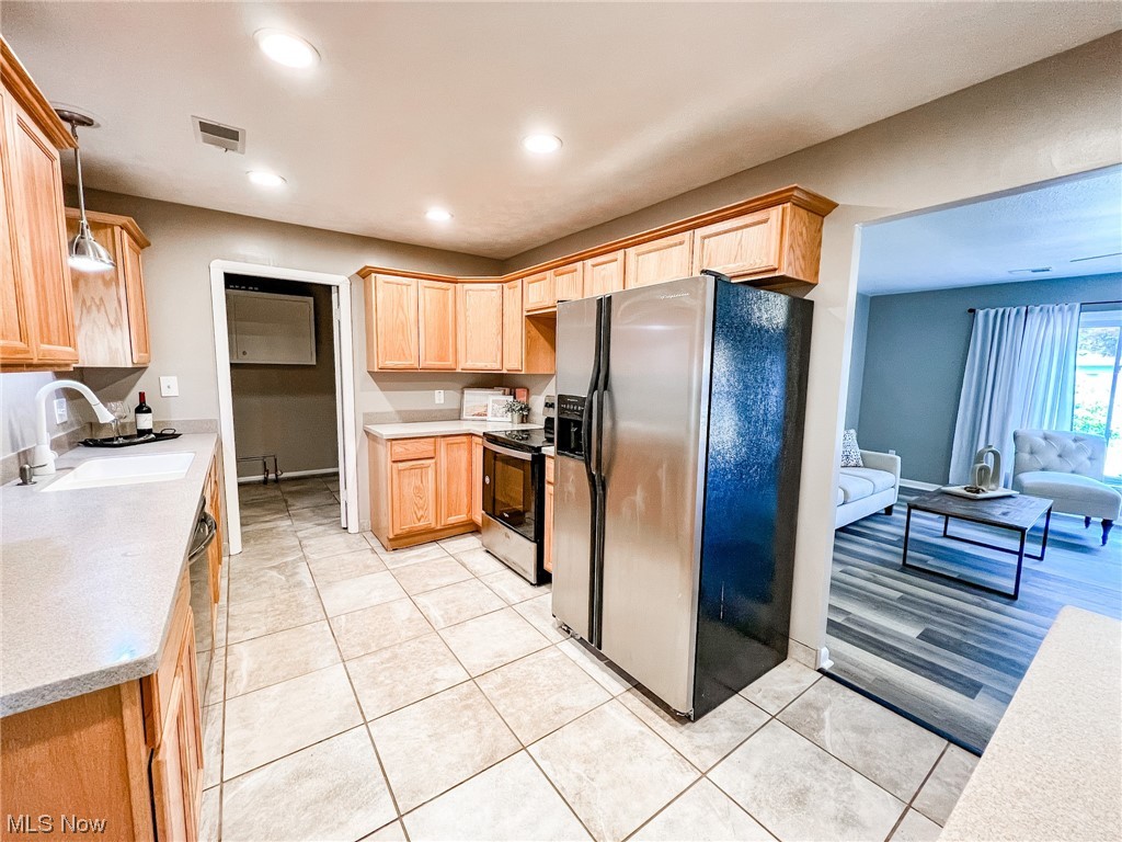 6830 Oakwood Road Parma Heights, OH 44130 - Photo 6 of 22 Kitchen featuring sink, light hardwood / wood-style flooring, stainless steel fridge with ice dispenser, electric range oven, and decorative light fixtures