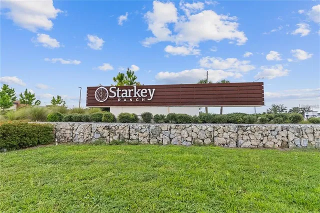 a front view of a house with a yard and potted plants