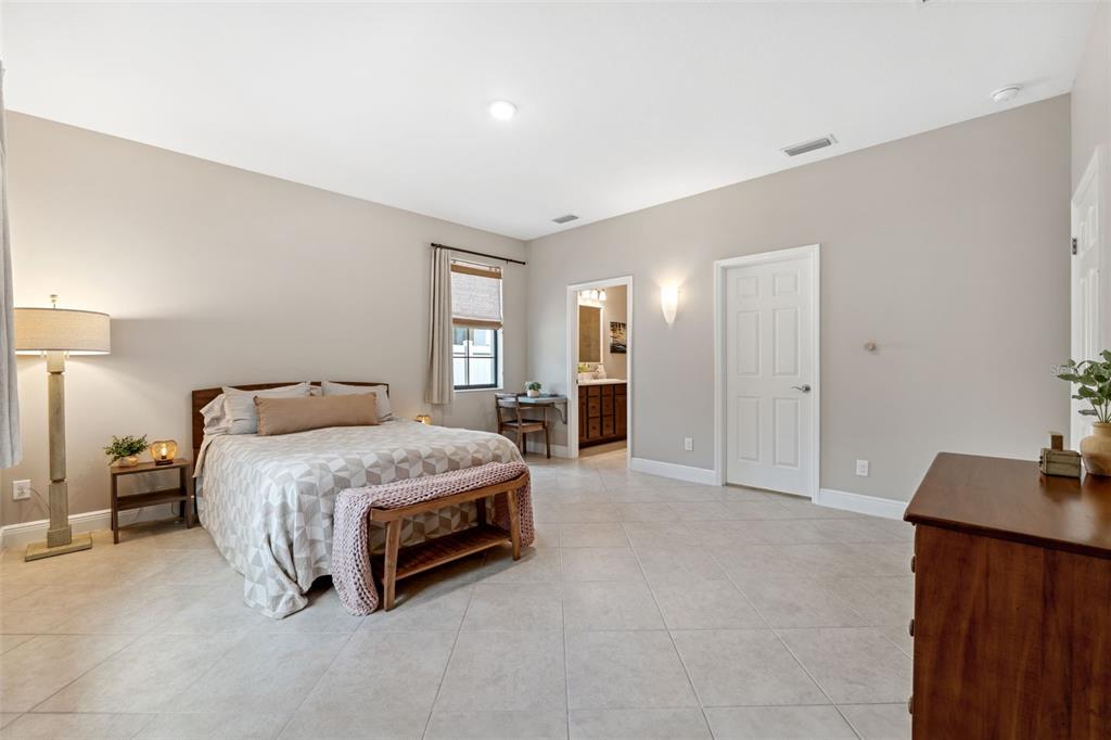 3877 Burdick Loop Odessa, FL 33556 - Photo 24 of 64 a spacious bedroom with a bed and cabinets