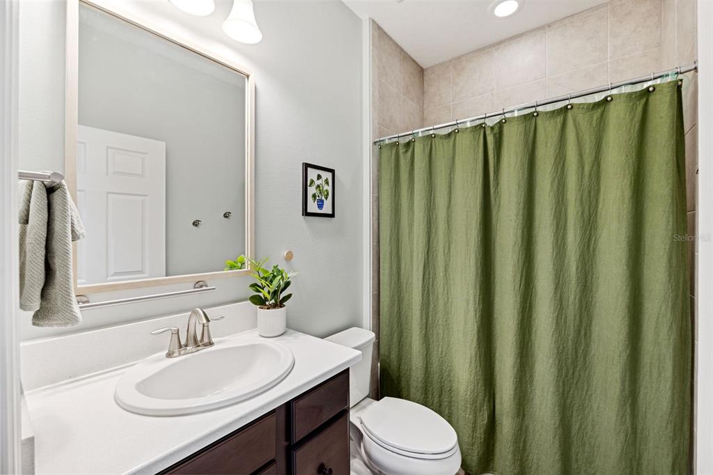 3877 Burdick Loop Odessa, FL 33556 - Photo 31 of 64 a bathroom with a sink a toilet and shower curtain