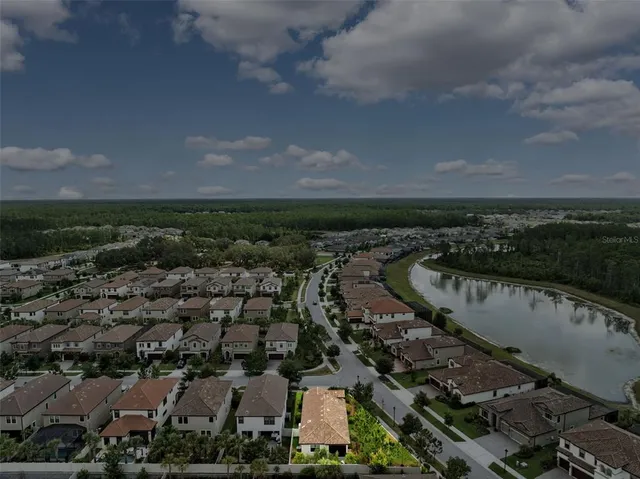 an aerial view of a house with a yard and lake view