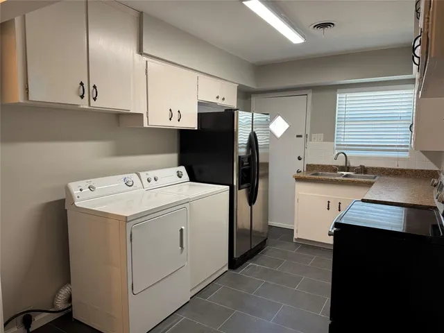 a kitchen with a sink a refrigerator and cabinets