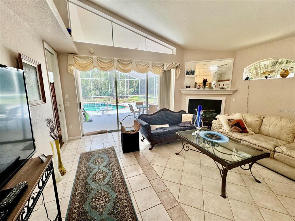 5688 Legend Hills Lane Spring Hill, FL 34609 - Photo 12 of 74 a living room with furniture fireplace and a floor to ceiling window