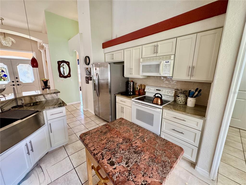 5688 Legend Hills Lane Spring Hill, FL 34609 - Photo 23 of 74 a kitchen with stainless steel appliances granite countertop a sink stove and refrigerator