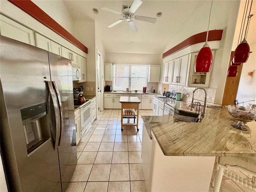 5688 Legend Hills Lane Spring Hill, FL 34609 - Photo 24 of 74 a kitchen with stainless steel appliances granite countertop a refrigerator and a stove