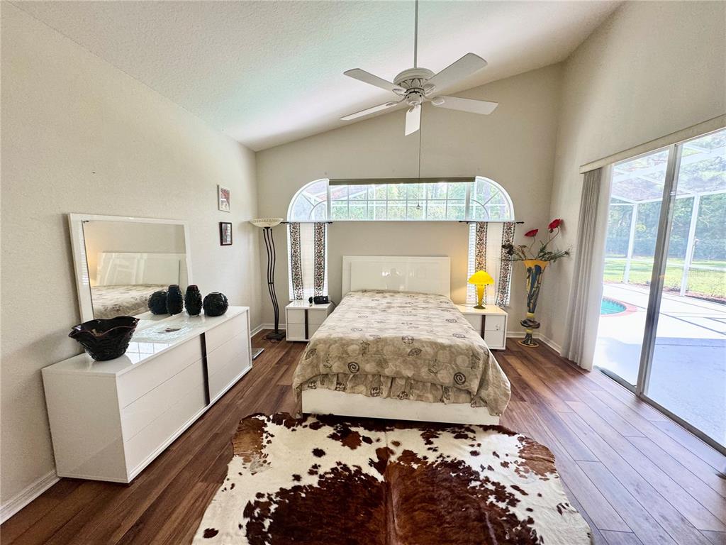 5688 Legend Hills Lane Spring Hill, FL 34609 - Photo 28 of 74 a bedroom with a large bed and a chandelier