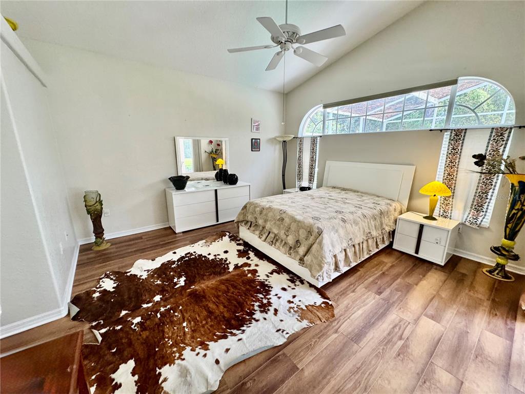 5688 Legend Hills Lane Spring Hill, FL 34609 - Photo 29 of 74 a bedroom with a bed and wooden floor