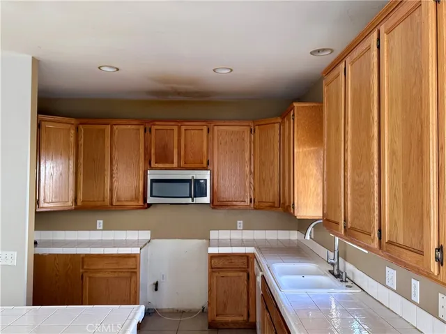 a kitchen with granite countertop a stove a sink and a microwave